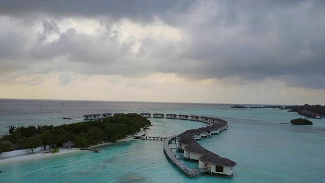 鸟瞰图的热带岛屿度假酒店与白色的沙棕榈树和绿松石印度洋上的马尔代夫视频素材