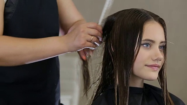 美发师在发廊为少女客户梳头视频下载