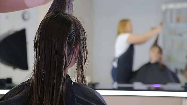 美发师在发廊为十几岁的少女客户理发视频素材