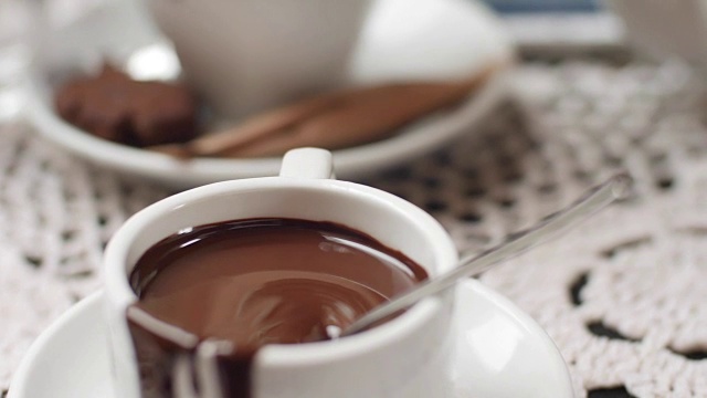 在热牛奶中手工搅拌巧克力，准备热巧克力或可可，漂亮的软焦镜头视频下载