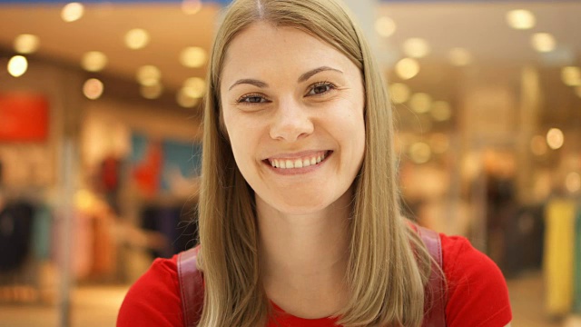 年轻美丽迷人的女人站在购物中心，微笑着。购物消费的概念视频素材