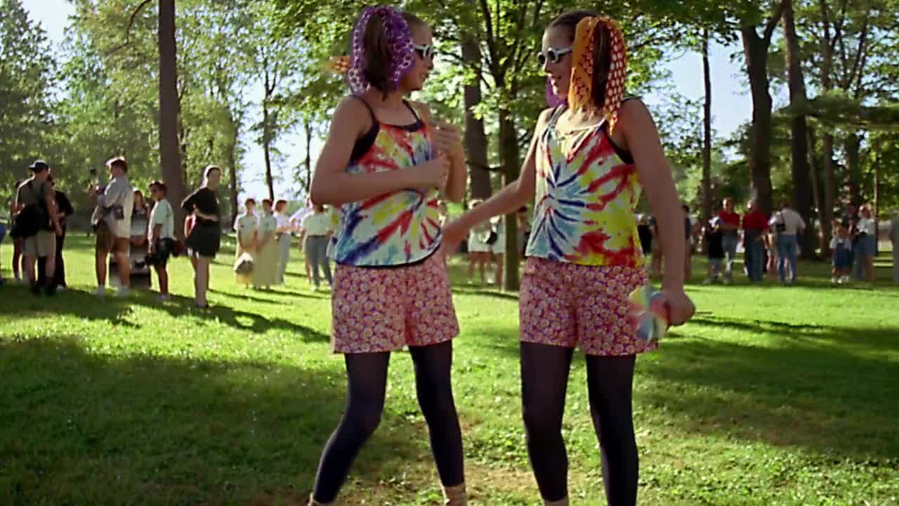 慢动作中拍摄双胞胎女孩在古怪的服装与太阳镜摆姿势和拥抱视频下载
