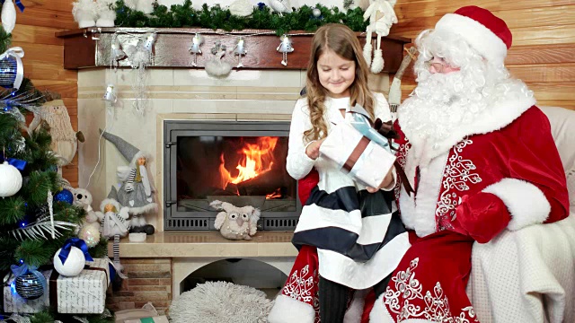 圣诞老人送女孩礼物，快乐微笑的孩子，愿望成真，新年和圣诞节庆祝视频素材