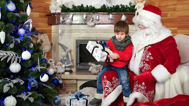 圣诞老人给男孩大礼物，愿望成真，快乐的孩子拥抱圣诞老人，礼物给孩子视频素材