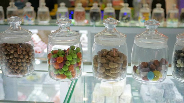 拍摄面包店里的糖果，货架上五颜六色的棒棒糖，圆润、美味、光泽、多色、半透明、吸引人视频下载