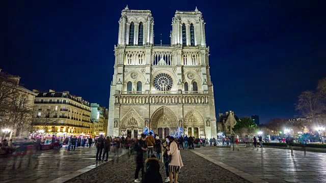 法国夜间照明著名的巴黎圣母院拥挤的广场全景，4k时间推移视频素材
