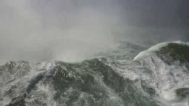 近距离观察:雾气蒙蒙的尼亚加拉大瀑布从悬崖边上掉下来，砸在底部的岩石上视频素材