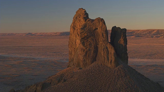 空中飞行，野猪牙火山遗迹在广阔的沙漠，在金色的日出视频素材