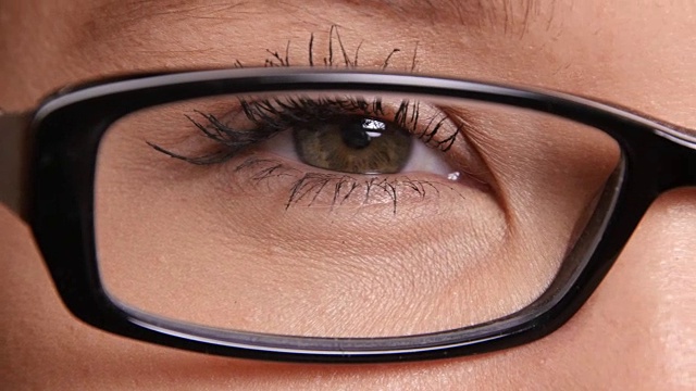 一个戴眼镜的年轻女人的眼睛的极端特写视频素材