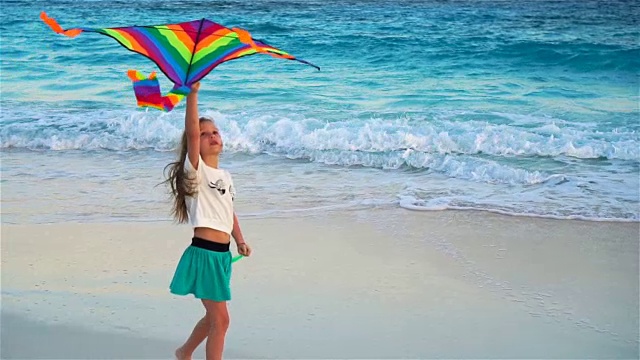 小女孩在热带海滩上放风筝。孩子们在海边玩耍。慢镜头里，孩子在玩海滩玩具视频素材