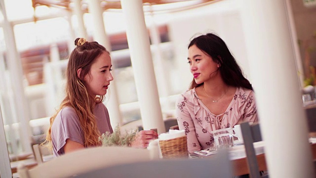 年轻女子享受他们的时间一起在一个传统的咖啡馆视频素材