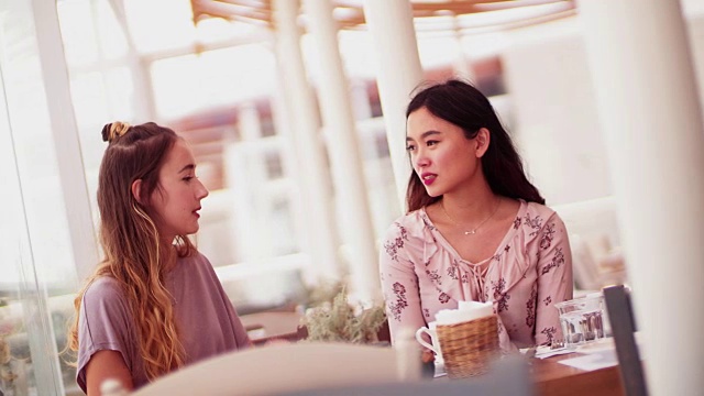 美丽的多民族妇女坐在和谈论在希腊岛餐厅视频素材