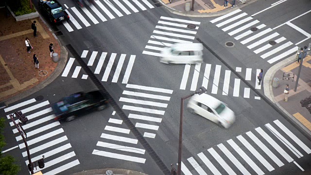 福冈人行横道交通的鸟瞰图。人群和汽车穿过马路。运动模糊视频素材