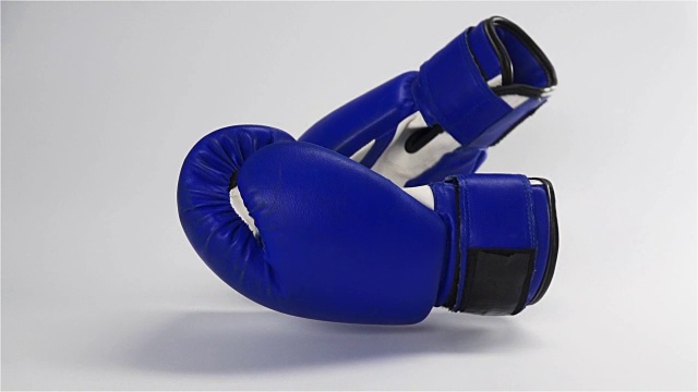 老式深蓝拳击手套落在白色表面视频下载
