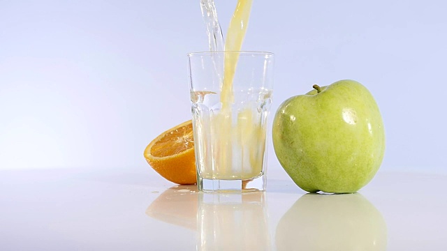 把苹果汁和桔子倒进玻璃杯里。苹果酒。新鲜的苹果视频素材