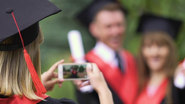 年轻的女士在学术服装拍照的朋友从大学毕业视频下载