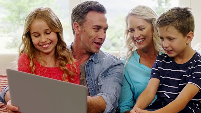 快乐的家庭在客厅使用笔记本电脑视频素材