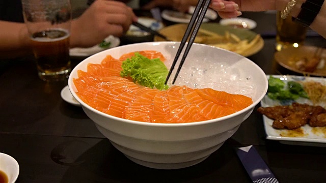 生鱼片在菜和汤头上食用;快速运动视频素材