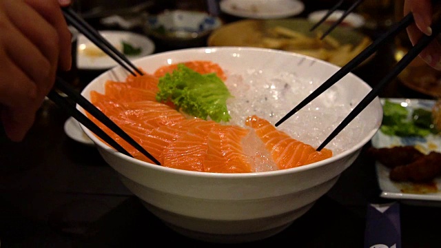 生鱼片在菜和汤头上食用;慢动作视频素材