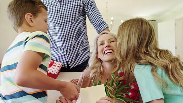 父亲和他的孩子们在客厅给妻子惊喜的礼物视频素材