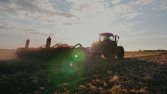 拖拉机在日落时耙地。替身拍摄视频素材