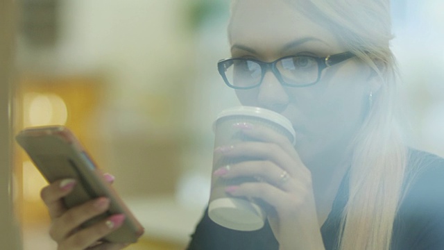 在咖啡馆喝咖啡和用手机的女人视频素材