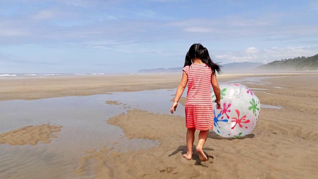 女孩跑和踢在海滩上的大球视频下载