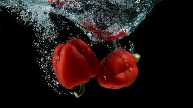 红甜椒，辣椒，黑色背景下蔬菜落水，4K慢镜头视频素材