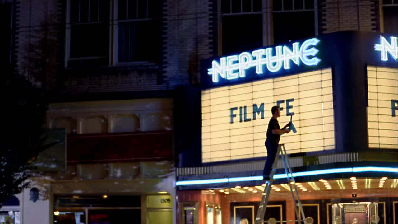 中枪男子在梯子上把字母放在电影院的大招牌上/人们离开电影院/西雅图视频素材