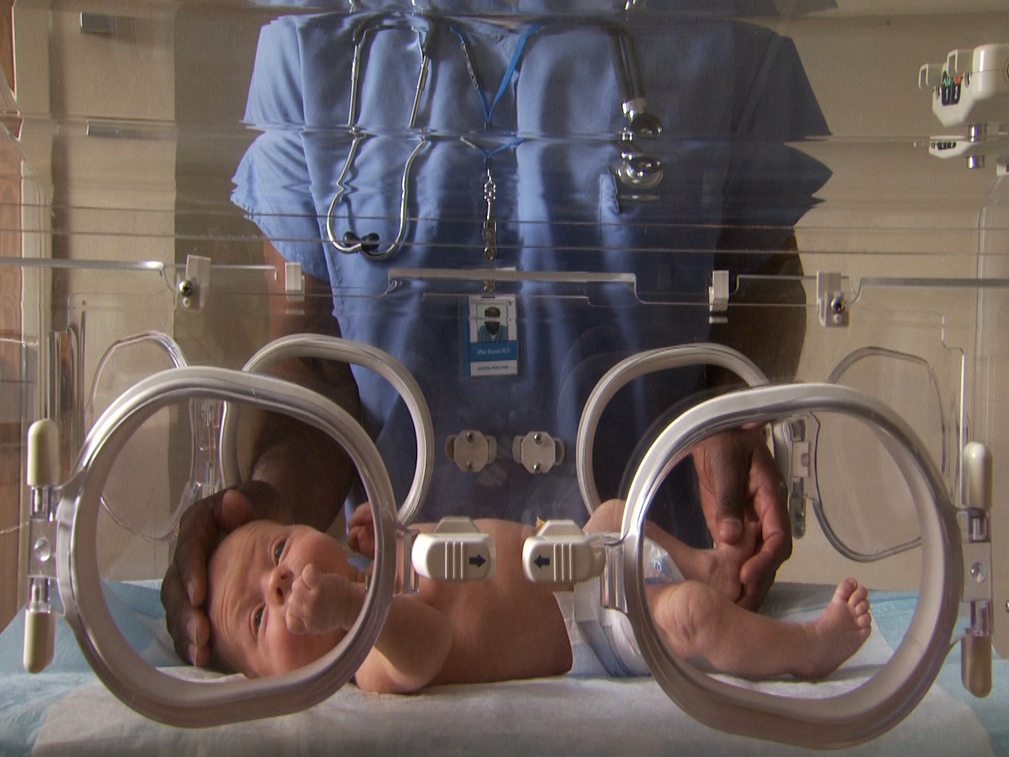 男医护人员在孵化器中爱抚新生儿视频下载