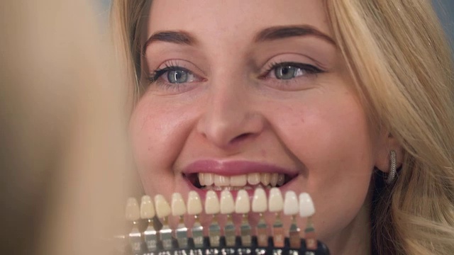 女牙医在牙医那里检查牙齿美白。视频下载