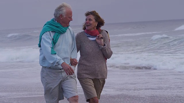 一对老年夫妇一起在海滩上散步视频素材
