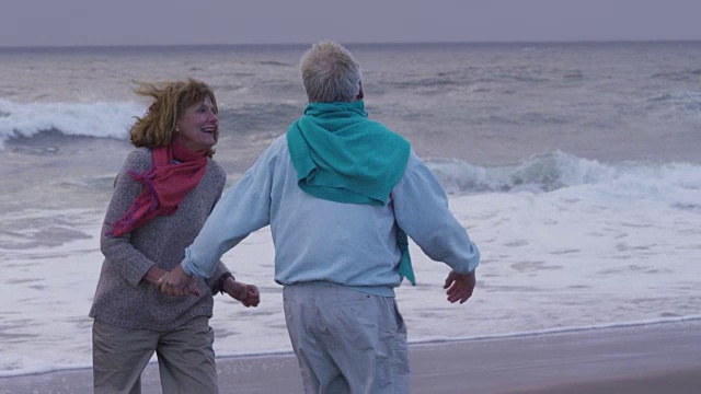 一对老年夫妇一起在海滩上散步视频下载