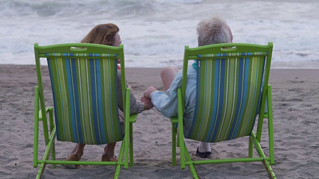 老夫妇一起坐在海滩上视频素材