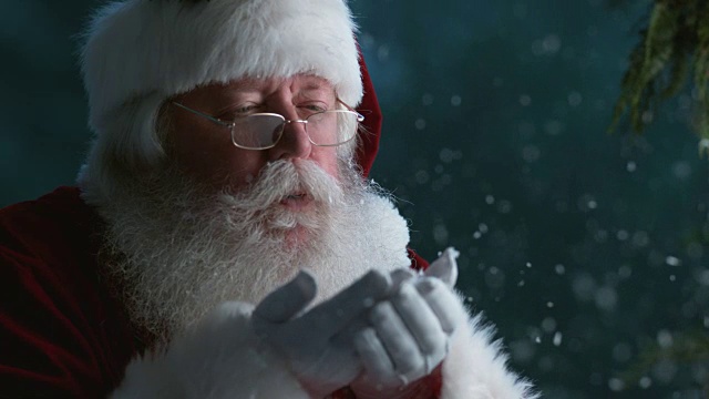 圣诞老人用慢动作从手上吹雪视频素材