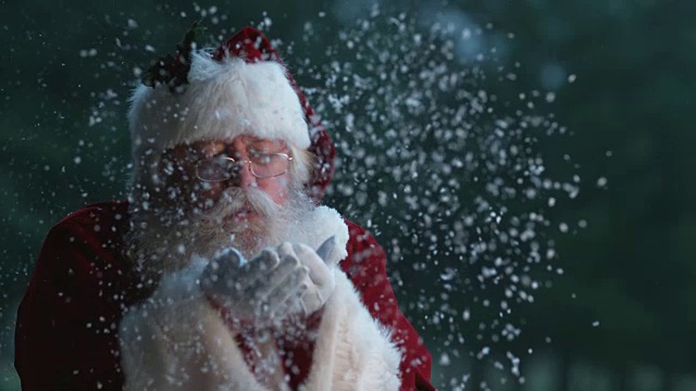 圣诞老人用慢动作从手上吹雪视频素材