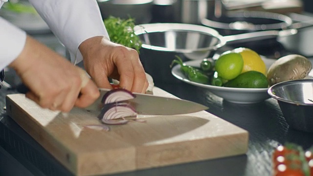 厨师在切菜板上熟练地切五颜六色的蔬菜和洋葱的特写。视频素材