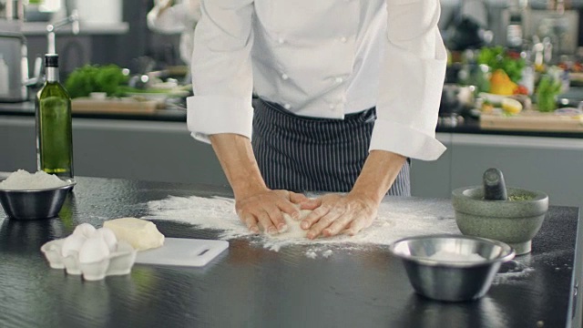 著名餐厅的面包师在现代化的厨房里揉面。视频素材