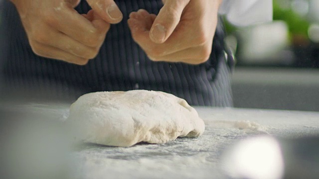 著名餐厅的面包师在现代化的厨房里揉面。视频素材