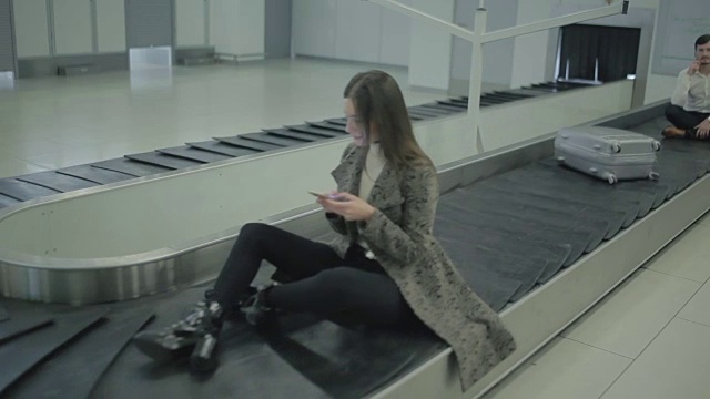 人们坐在机场的传送带上视频素材
