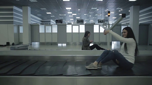 成年人坐在机场的移动行李传送带上视频素材