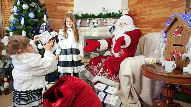 小女孩们帮圣诞老人拿圣诞礼物，圣诞老人冬天住，给孩子们送礼物视频素材