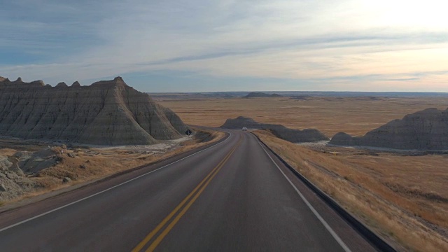 沿着这条路往下走，经过Badlands国家公园里巨大的砂岩山视频素材