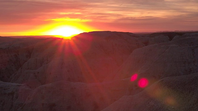 AERIAL: Badlands公园砂岩山背后令人惊叹的红色日落视频素材