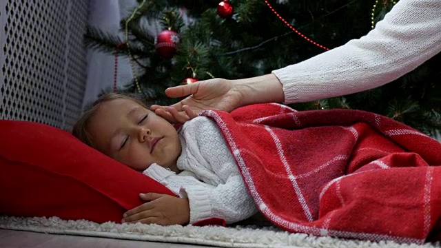 可爱的小女孩早上睡在圣诞树下视频下载