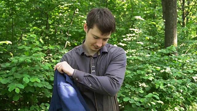 穿着夹克的年轻商人站在森林里视频下载
