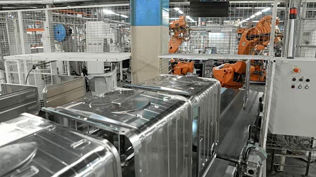 延时工业机器人将金属物体放在工厂的传送带上视频素材