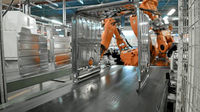 延时工业机器人在传送带上放置金属框架视频素材