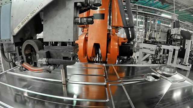 LD工业机器人在工厂里将一个模压的金属板固定在底座上视频素材