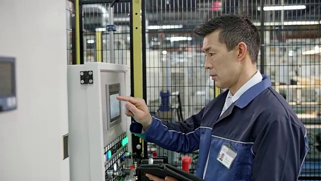 工厂里的工人用触摸屏插入数据视频素材